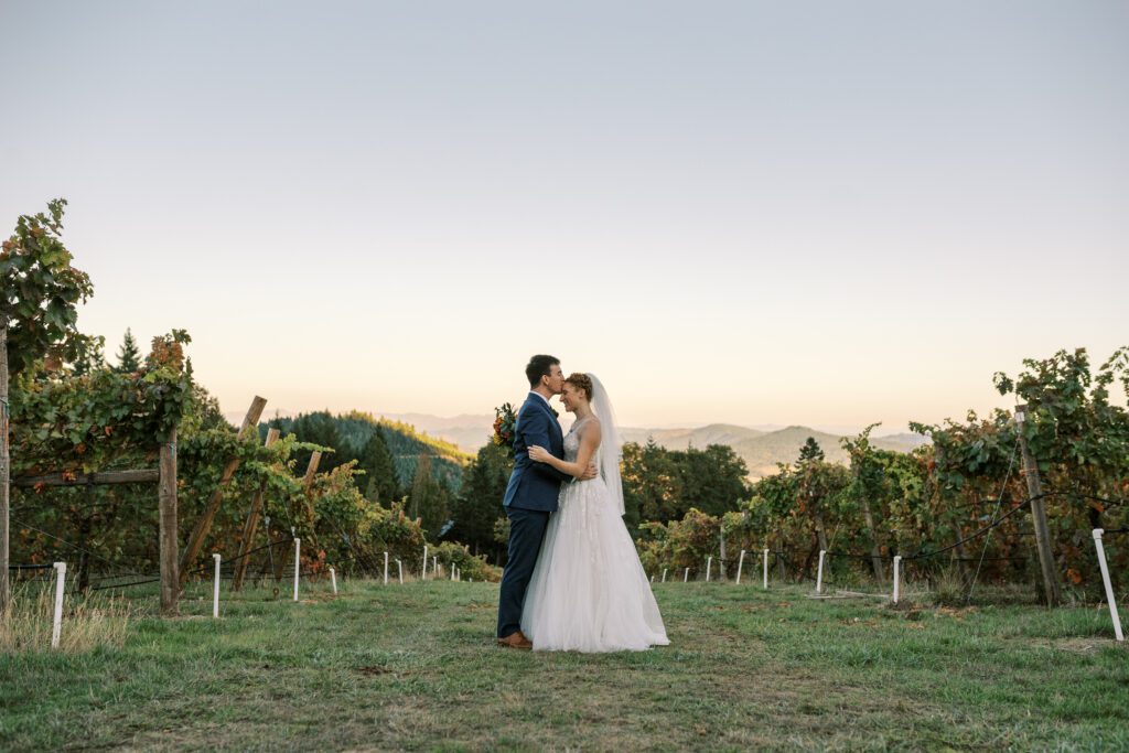 newlyweds in the vineyard at spire mountain cellars